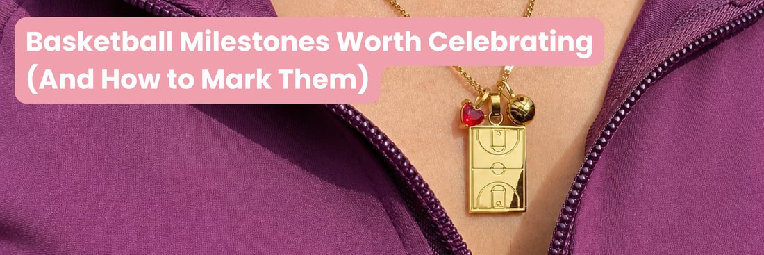 Gold Home Court basketball necklace with basketball court pendant, basketball charm and red heart gem charm worn with a purple athletic jacket, featured in an article about celebrating basketball milestones.