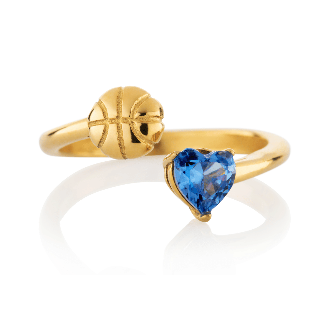 Gold Follow Through basketball ring with blue heart-shaped gemstone and basketball detail on a white background