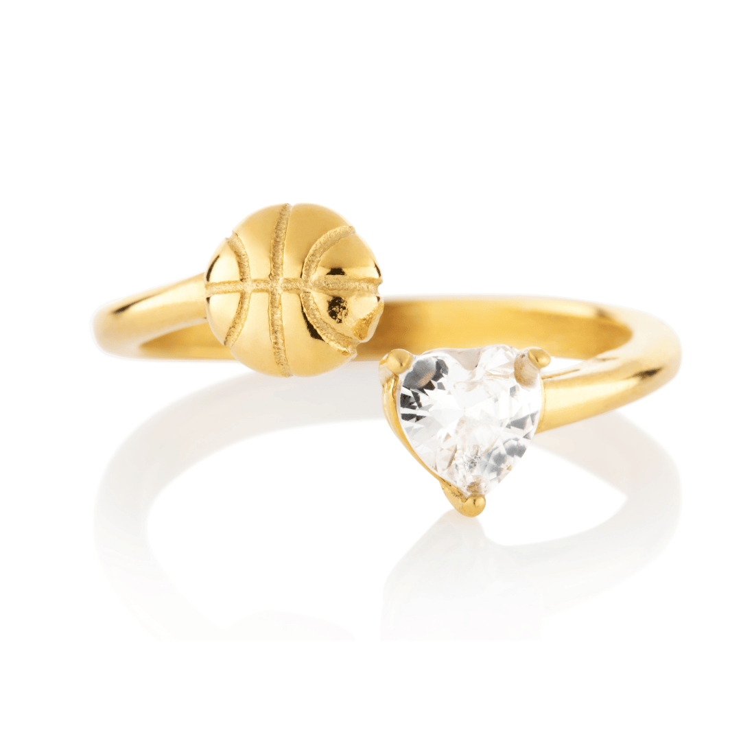 Gold Follow Through basketball ring with clear heart-shaped gemstone and basketball detail on a white background