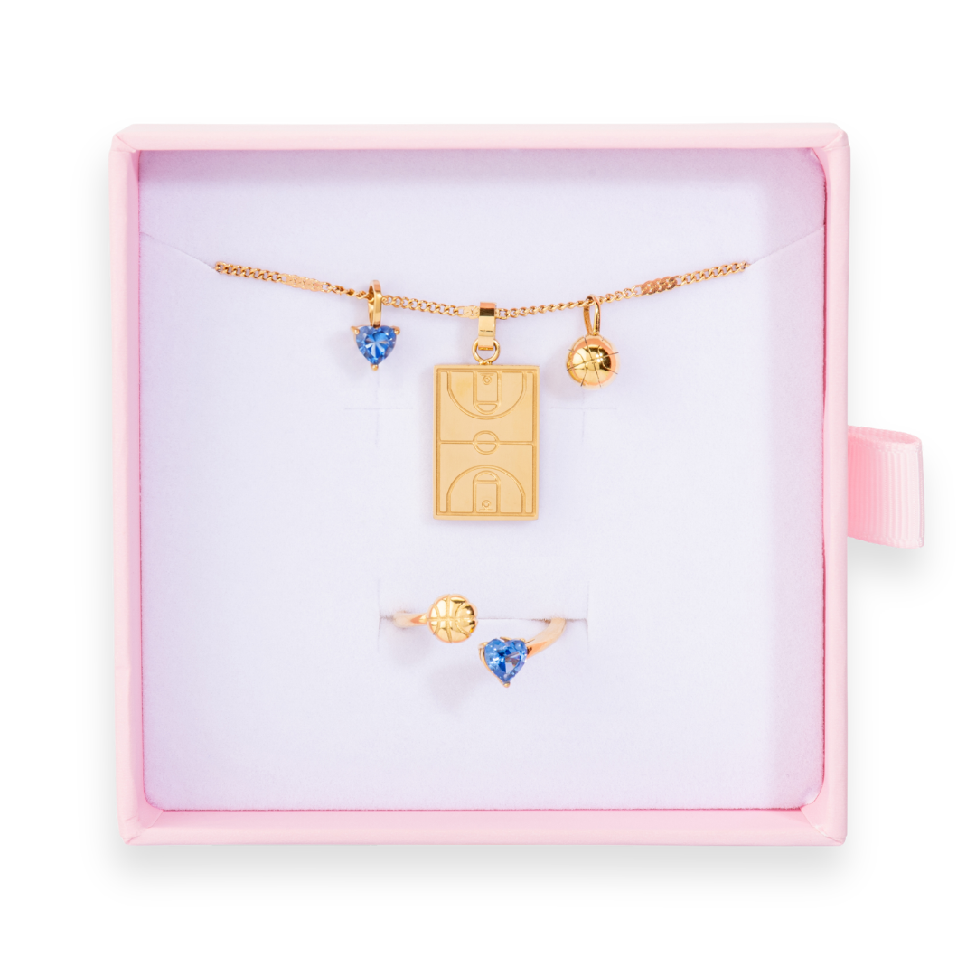 Gold Follow Through basketball jewelry bundle featuring a Home Court basketball necklace and matching blue gold follow through basketball ring displayed in a pink gift box